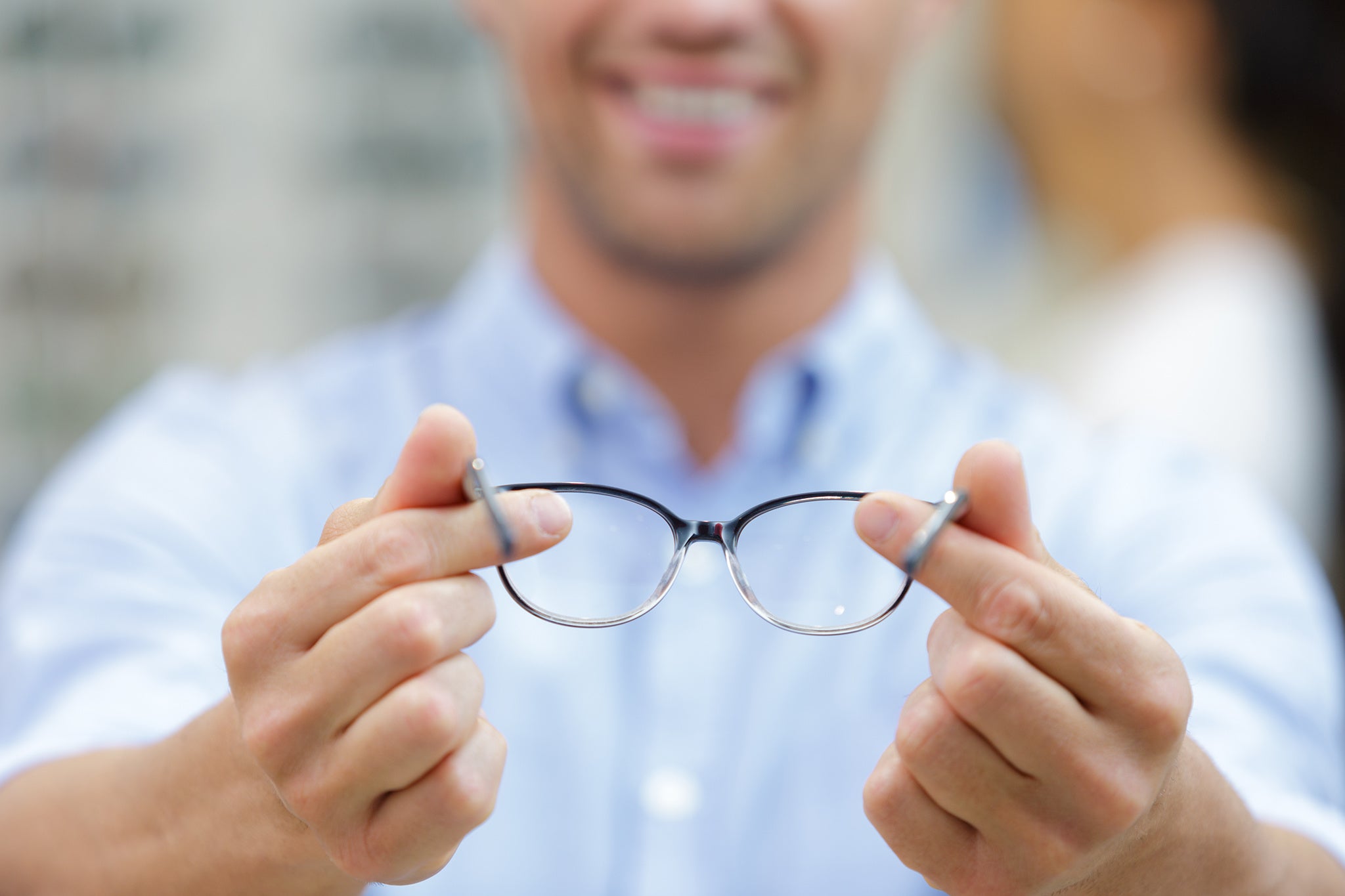 close up view of spectacles held by male optician